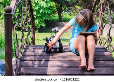 Minsk, Belarus - May, 2018: Little Girl Programs Lego Robot Mindstorms EV3 On IPad Apple In Summer Stem Robotic Camp. Elementary School In The Garden. Robotic Class. Lesson. AI. Code Bot.