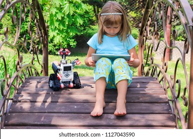 Minsk, Belarus - May, 2018: Little Girl Programs Lego Robot Mindstorms EV3 On IPad Apple In Summer Stem Robotic Camp. Elementary School In The Garden. Robotic Class. Lesson. AI. Code Bot.