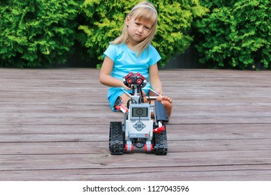 Minsk, Belarus - May, 2018: Little Girl Programs Lego Robot Mindstorms EV3 On IPad Apple In Summer Stem Robotic Camp. Elementary School In The Garden. Robotic Class. Lesson. AI. Code Bot.