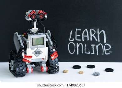 Minsk, Belarus. May, 2020. Concept learn online. Distance learning. Robotics and programming education. Lego Spike prime robot and blackboard with an inscription in the background.