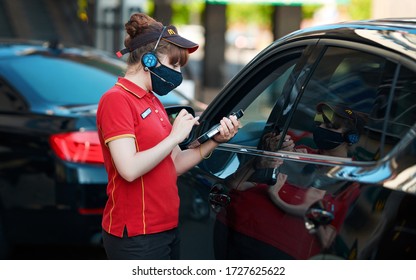 Minsk, Belarus. May 2020. Costumer Ordering Food From Car On McDrive, McDonald`s Fast Food Restaurant. McDonald's Employee In Protective Mask Takes Orders With Tablet At McDrive