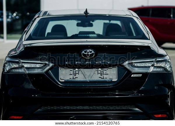 Minsk, Belarus,\
May 2022 - Car Toyota Camry parking on the asphalt road. The\
official dealer of Toyota who is the top market share for\
commercial car. rear lights of\
automobile