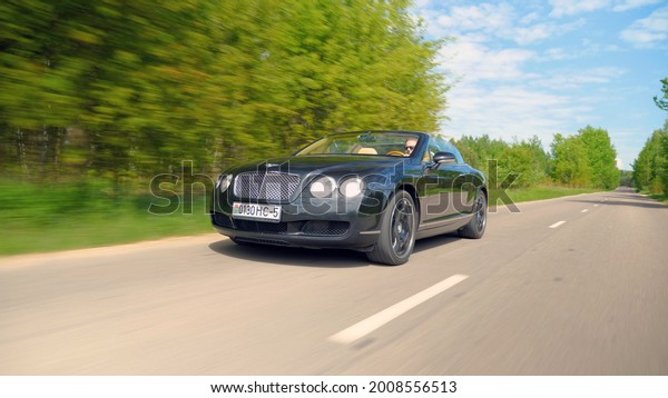 MINSK, BELARUS - MAY 31, 2021: Bentley\
Continental GT Cabrio drives on a highway. This British car is\
powered by W12 bi-turbo 6.0-l\
engine.