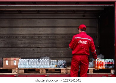 Minsk, Belarus - Nov 2018. Lorry with boxes of Coca-cola, water and juice. Delivery worker checks an order. food delivery to a restaurant, pub, cafe