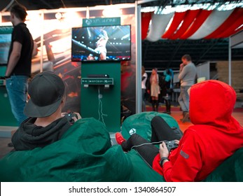 Minsk, Belarus - Nov 2018. Young Boys Gamers With Gamepad Or Joystick Playing Video Game In Crowd During Tournament On Unicon Convention, Game Expo. Gaming, Fun, Leisure Time And Entertainment Concept