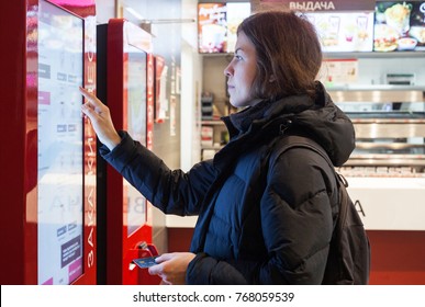 MINSK, BELARUS - november 26, 2017: Woman uses KFC kiosk to order food at KFC restaurant