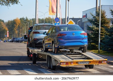 Minsk, Belarus. Oct 2021. Car carrier hauling new VW Polo and VW Taos. Car carrying trailer, transporting VW cars at city street.