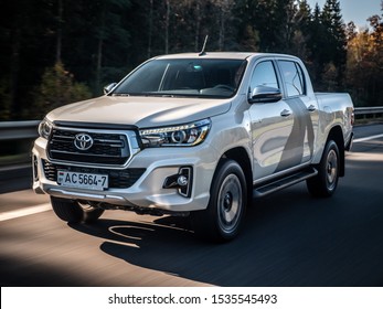 MINSK, BELARUS - October 17, 2019: Pearl white Toyota Hilux 2.8 D-4D drives on a highway during bright sunny day.