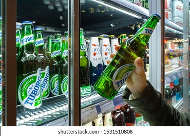 MINSK, BELARUS - October 4, 2019: Buyer Takes Tuborg Beer In Refrigerator Of Supermarket. Hand Is Holding Tuborg Beer.