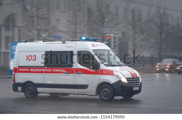 Minsk, Belarus- Sep 2019. Ambulance\
moving fast on Nezavisimosti Avenue with flashing lights on.\
Emergency ambulance driving fast on the road in the\
fog.