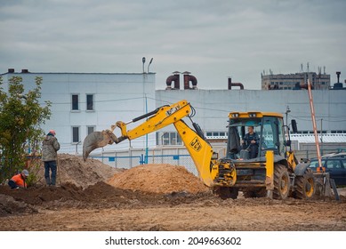Minsk, Belarus. Sep 2021. JCB excavator working at construction site, all-wheel drive backhoe loader working. JCB excavation work on construction site.  Yellow tractor works