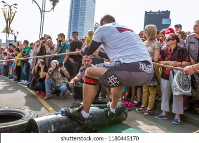Minsk, Belarus-September 9,2018: bodybuilder athlete strongman pulls car at city tournament on holiday city day in Minsk