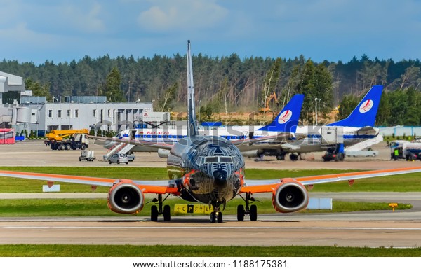Minsk, National Airport, 08.07.2018: The black\
airplane of Belavia Airlines Boeing 737-300 painted in the logo of\
the company Wargaming in the style of the popular computer game\
World of Tanks.