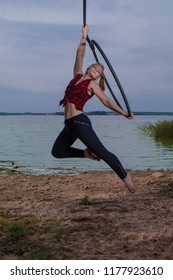 MINSK, REPUBLIC OF BELARUS - SEPTEMBER 3, 2018: Field training aerial gymnastics. Girls perform acrobatic on the ring on the lake. For these pictures a neutral density filter and an external flash.