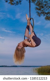 MINSK, REPUBLIC OF BELARUS - SEPTEMBER 3, 2018: Field training aerial gymnastics. Girls perform acrobatic on the ring on the lake. 

For these photos a neutral density filter and an external flash.
