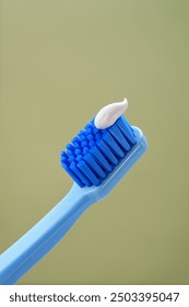 Mint background. Blue toothbrush with toothpaste on a green background, close-up. 