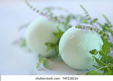 Mint bath bomb.  green bath bombs with mint extract and twigs of flowering mint on a light gray wooden background. Cosmetics for bath. 