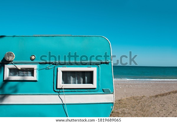 A mint green\
Caravan near the sea. Family vacation travel, holiday trip in\
motorhome, Caravan car\
Vacation.