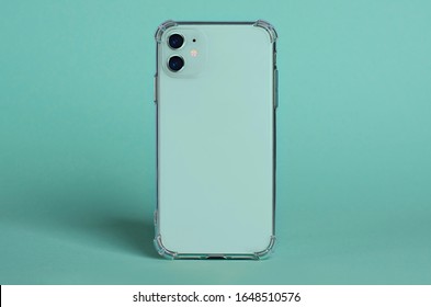 Mint Green IPhone 11 In Clear Silicone Case Back View. Phone Case Mockup Isolated On Green Background