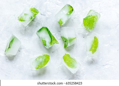 mint in ice cubes stone background top view