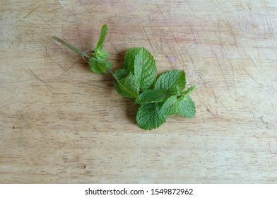 Mint leaves on a wooden table of a kitchen - Shutterstock ID 1549872962
