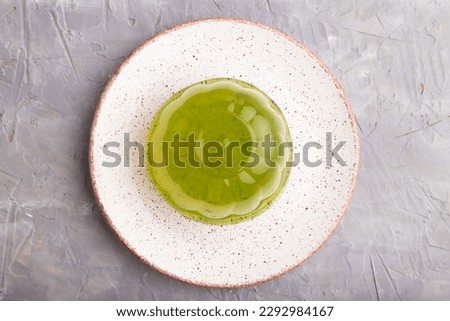 Mint and raspberry green jelly on gray concrete background. top view, flat lay, close up.