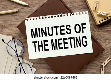 Minutes of meeting torn page on a brown notepad. glasses and pencils - Shutterstock ID 2260099495