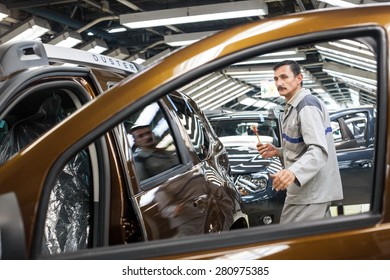 Mioveni, Romania - October 13, 2014: Color Picture Of A Worker On The Assembly Line Of The Dacia Renault Factory.