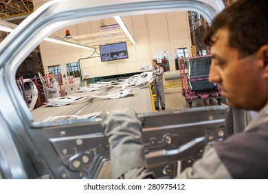 Mioveni, Romania - October 13, 2014: Color Picture Of Workers On The Assembly Line Of The Dacia Renault Factory.