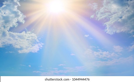 Miraculous Heavenly Light -  Blue sky, fluffy clouds and a beautiful warm orange yellow sun beaming down radiating depicting a holy entity 
 - Shutterstock ID 1044944476