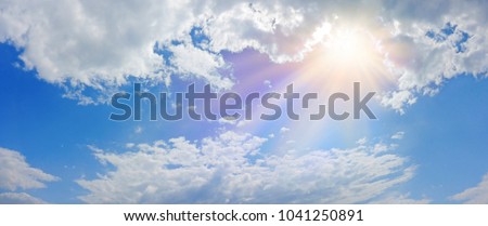 Miraculous Heavenly Light Panorama Banner -  Wide blue sky, fluffy clouds and a beautiful warm orange yellow sun beaming down radiating depicting a holy entity 