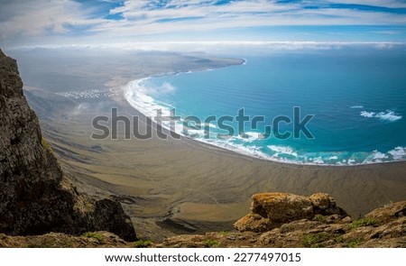 Mirador Rincon de Haria, high angle view on the dramatic northern coastline of the Canary island Lanzarote. Famara beach in the far distance.