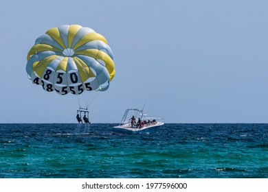 Miramar Beach, Florida, United States - May 1, 2021. A pair of adventurers try parasailing just off Miramar Beach, Florida, on May 1, 2021.