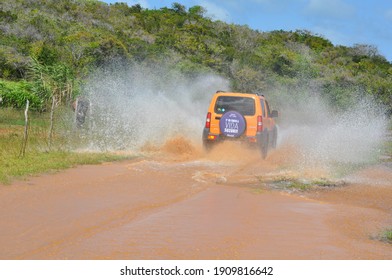 Ceará Mirim, Rio Grande Do Norte, Brazil - October 25 2015: A Car Moving Forward On A Flooded Dirt Road, Splashing The Water Around.