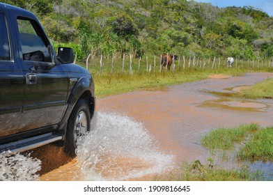 Ceará Mirim, Rio Grande Do Norte, Brazil - October 25 2015: A Car Moving Forward On A Flooded Dirt Road, Splashing The Water Around.