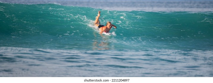 Mirissa, Sri Lanka - 04 09 2022: Female Surfer Trying To Get Onto The Wave, Swimming With The Wave, And Moving Forward To Gain Speed And Momentum.