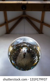 Mirror, Brilliant, Reflective Disco Ball Hanging On A Chain From The Ceiling. Close-up.