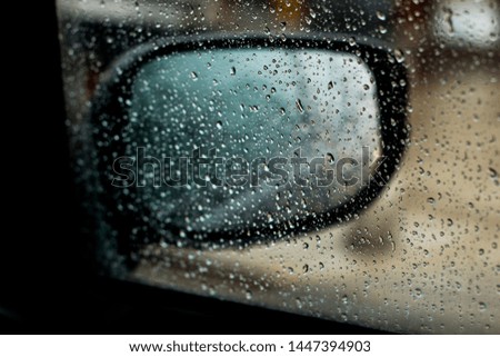 mirror car closeup with raining drops