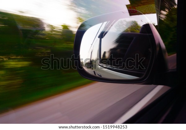 Mirror of the car when a car is running, Out\
of focus and blurred\
background.