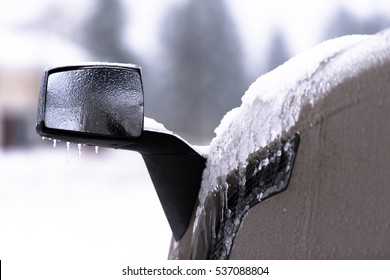 Mirror And Fender Of Semi Truck In Snow And Ice On Blurred Background