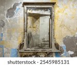 mirror, hanged mirror with old wooden frame on cracked stucco wall with copy space. Vintage wooden frame with a large old mirror, hanging on damaged historic stucco wall in an abandoned building, home