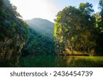 Mirror lake in Ipoh, Perak, Malaysia. The lake surrounded by limestone mountains with almost vertical slope and covered by greeneries.