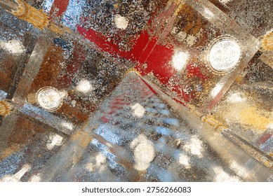 Mirror mosaic ceiling inside a temple with multiple light fixtures creating a reflective surface that forms bright patterns and detailed architectural design.