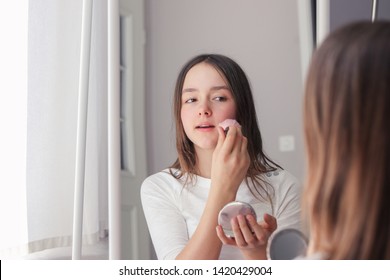 Mirror reflection of beautiful preteen girl putting powder with brush on her face. Make up and natural beauty concept. - Shutterstock ID 1420429004