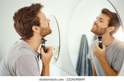 Reflejo espejo, afeitado y afeitado en el baño de una casa por la mañana para higiene personal. Alambre eléctrica, cuidado de la piel y rutina con un joven hombre en su casa para depilación