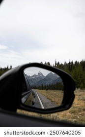 Mirror reflection of mountains while driving