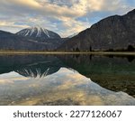 Mirror reflection of a snow-covered mountain in a lake with mountain water in Martigny, Switzerland
