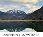 Mirror reflection of a snow-covered mountain in a lake with mountain water in Martigny, Switzerland