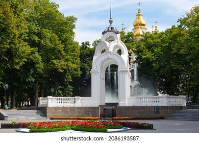 Mirror Stream fountain in park with flowers and green trees, Myrrh-bearing temple of Kharkov in background, Ukraine
