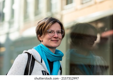 Mirrored Portrait Of A 35 Year Old Woman Wearing A Grey Hoody